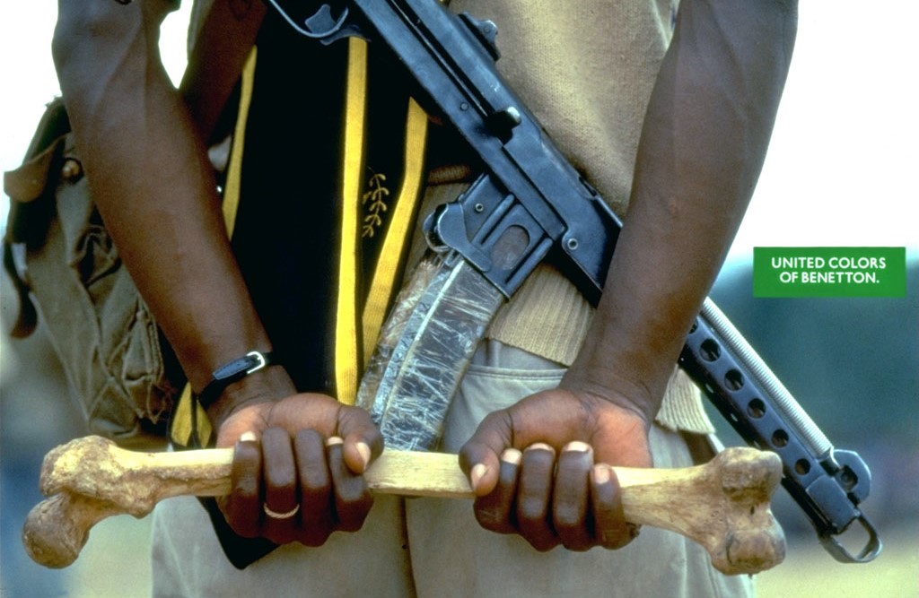 Zdjęcie człowieka z bronią trzmającego kość. © United Colors of Benetton / Oliviero Toscani